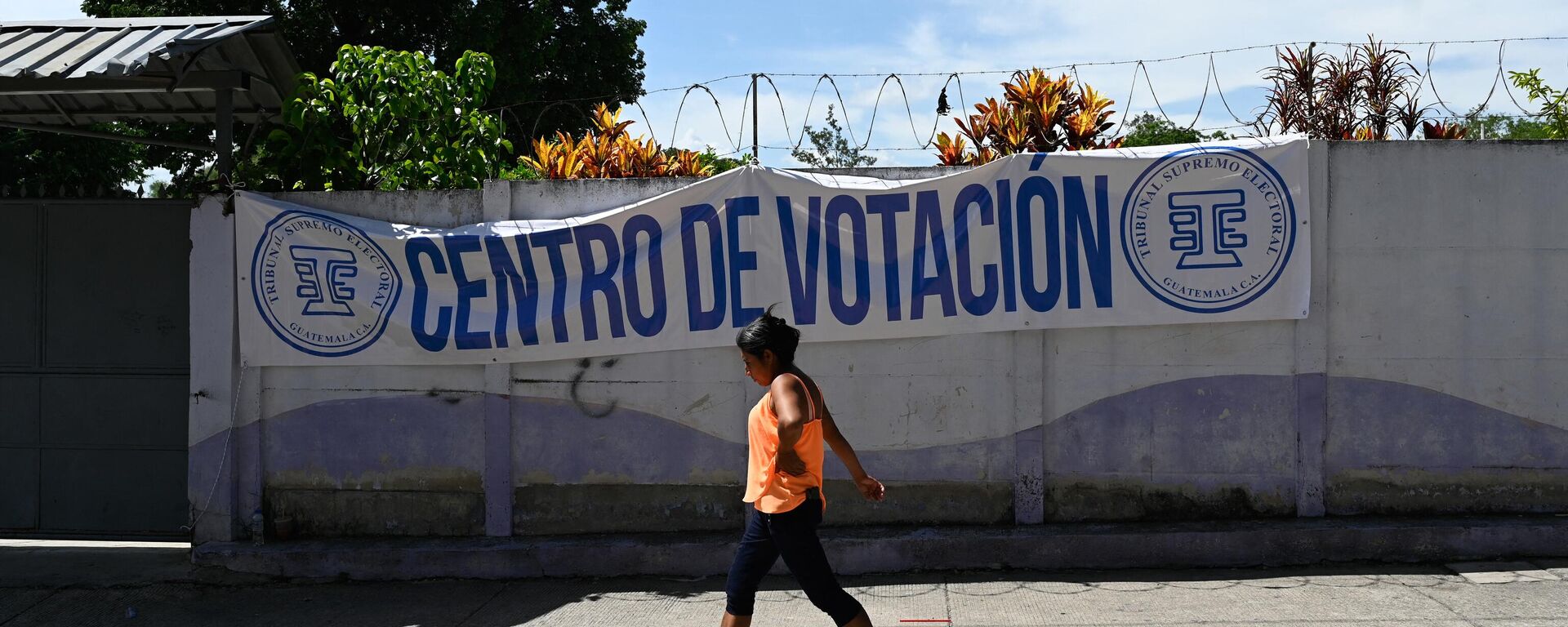 Una mujer pasa junto a un colegio electoral en San José del Golfo, Guatemala, el 26 de junio de 2023 - Sputnik Mundo, 1920, 13.07.2023