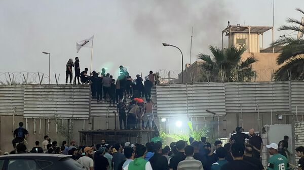 Manifestantes escalan un muro de la embajada sueca en Bagdad enojados por la quema de Corán en Estocolmo - Sputnik Mundo