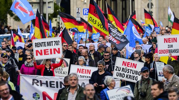 Un manifestante sostiene un cartel con la leyenda No a la jubilación a los 70 durante una concentración de grupos de extrema derecha, entre ellos el partido Alternativa para Alemania (AfD), contra la subida de precios en Berlín, el 8 de octubre de 2022. - Sputnik Mundo