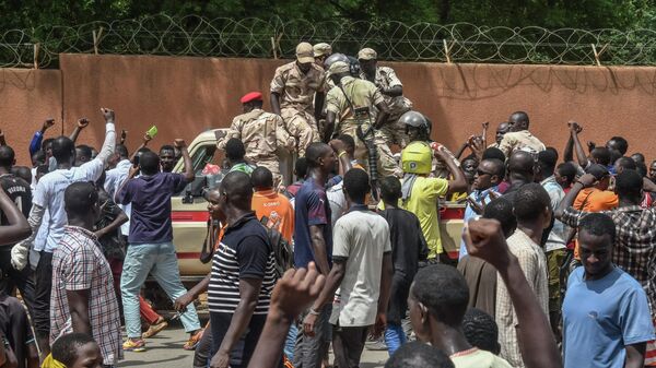 Manifestantes aclaman a las tropas nigerinas mientras se reúnen frente a la embajada francesa en Niamey durante una manifestación que siguió a un mitin de apoyo a la junta de Níger el 30 de julio de 2023.  - Sputnik Mundo