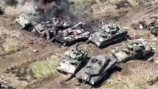 Un tanque Leopard 2 y un vehículo de combate Bradley entre numerosos vehículos ucranianos destruidos - Sputnik Mundo