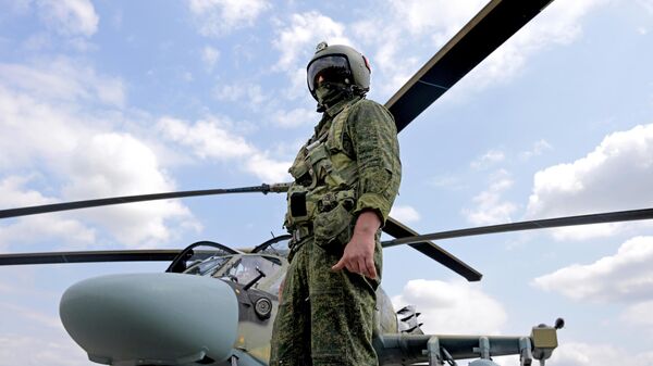 Un militar ruso y helicóptero de ataque Ka-52 - Sputnik Mundo