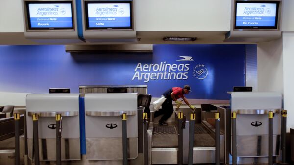 Un trabajador limpia el mostrador de facturación de Aerolíneas Argentinas en el aeropuerto de Buenos Aires, Argentina - Sputnik Mundo