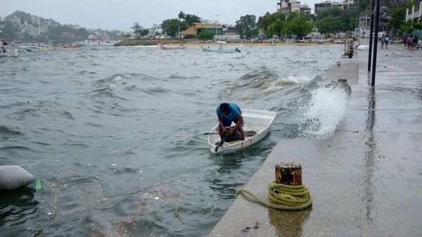 Un hombre amarra su embarcación en Acapulco, México, tras el paso de la tormenta tropical Hilary.  - Sputnik Mundo