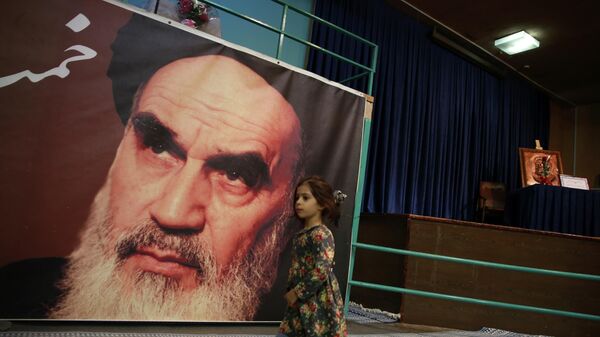 Una niña pasa por delante de un poster del ayatolá Ruhollah Jomeiní, en el norte de Tehrán - Sputnik Mundo