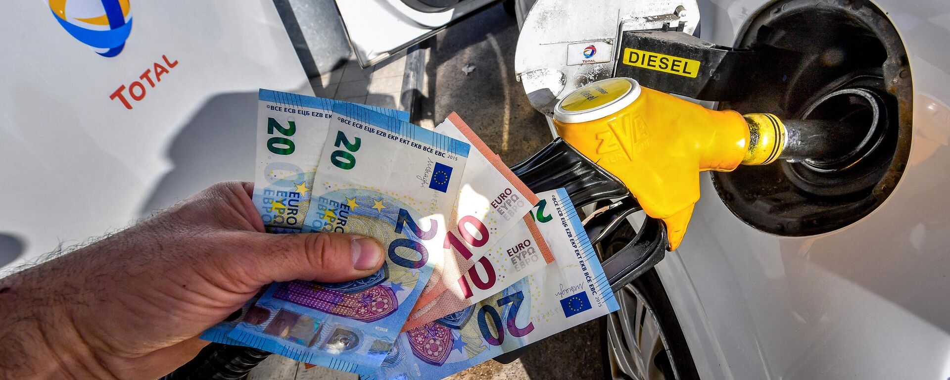 Un hombre sostiene en su mano billetes de euro en una gasolinera en Francia - Sputnik Mundo, 1920, 05.09.2023