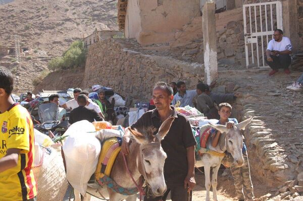 Adultos y niños participan en el reparto de ayuda en las montañas afectadas por el terremoto de Marruecos, 15 de septiembre de 2023 - Sputnik Mundo