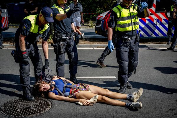 Agentes de Policía retiran a un activista climático del grupo Extinction Rebellion durante una manifestación contra la concesión de subvenciones a los combustibles fósiles por parte del Gobierno en La Haya, Países Bajos. - Sputnik Mundo