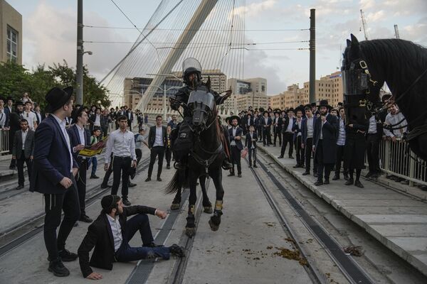 La Policía israelí dispersa a hombres y niños judíos ultraortodoxos que bloqueaban una carretera durante una protesta contra el servicio militar obligatorio, en Jerusalén. La Policía israelí dispersa a hombres y niños judíos ultraortodoxos que bloqueaban una carretera durante una protesta contra el servicio militar obligatorio, en Jerusalén. - Sputnik Mundo