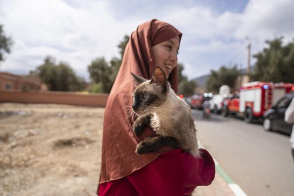 Una mujer sostiene un gato que rescató tras el terremoto, en la ciudad de Amizmiz, en Marruecos. - Sputnik Mundo