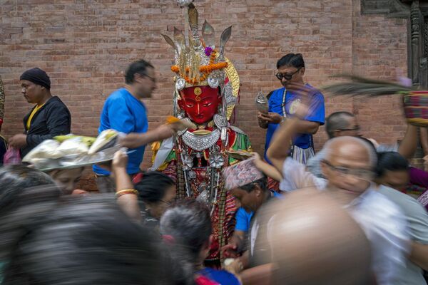 Devotos se reúnen en torno a un ídolo de Buda para rezar durante el festival Pancha Dan en Bhaktapur, Nepal. - Sputnik Mundo