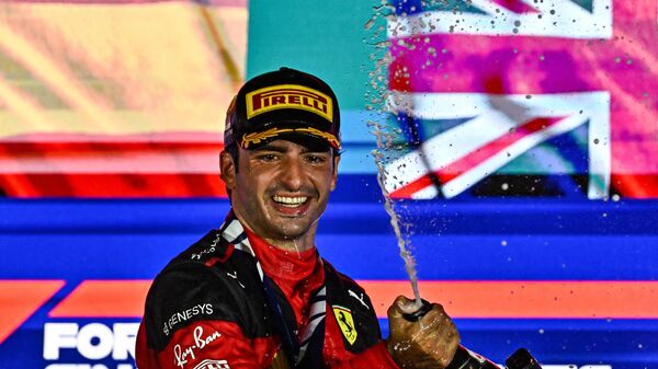 Carlos Sainz, el piloto español de Ferrari, rocía champán tras ganar la carrera nocturna del Gran Premio de Fórmula 1 de Singapur, el 17 de septiembre de 2023  - Sputnik Mundo