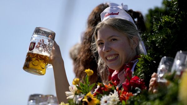 Женщина держит стакан пива на 188-м пивном фестивале Октоберфест в Мюнхене, Германия - Sputnik Mundo