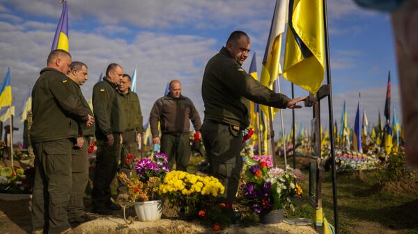 Militares ucranianos depositan flores en la tumba de un compañero soldado recientemente asesinado en un cementerio Járkov, Ucrania  - Sputnik Mundo
