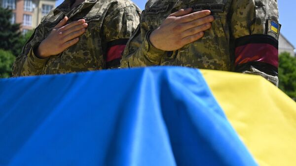 Soldados ucranianos presentan sus respetos junto a la tumba de un fallecido militar ucraniano - Sputnik Mundo