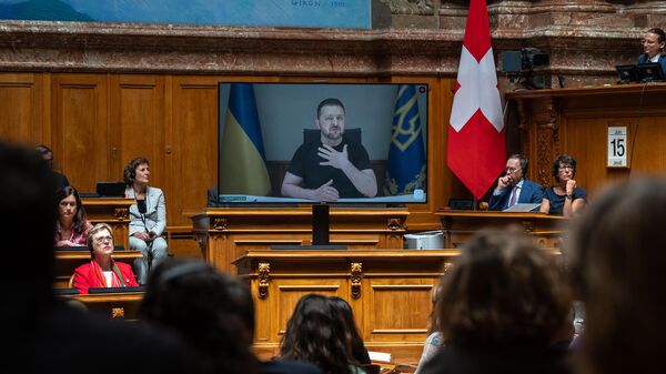 Volodímir Zelenski, el presidente de Ucrania, aparece en una pantalla dirigiéndose por videoconferencia al Parlamento suizo en Berna el 15 de junio de 2023  - Sputnik Mundo