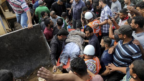 Palestinos trasladando a una víctima de los bombardeos israelíes en la Franja de Gaza - Sputnik Mundo