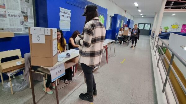 Una joven se acerca a votar en una mesa durante las elecciones generales de Argentina de 2023 - Sputnik Mundo