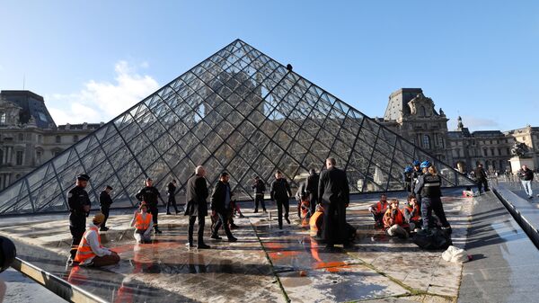 Activistas del grupo ecologista Derniere Renovation (Última Actualización), cuyo objetivo es concienciar sobre el cambio climático, son detenidos por agentes de Policía tras escalar la Pirámide del Louvre. - Sputnik Mundo