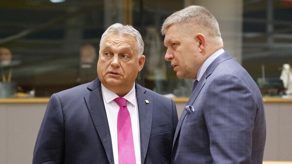 El primer ministro de Hungría, Viktor Orban, habla con el primer ministro de Eslovaquia, Robert Fico, antes del inicio de una Cumbre de líderes de la UE en el edificio del Consejo Europeo en Bruselas el 26 de octubre de 2023.  - Sputnik Mundo
