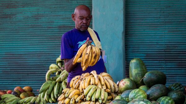 Un hombre comprando bananas en un puesto callejero de La Habana - Sputnik Mundo