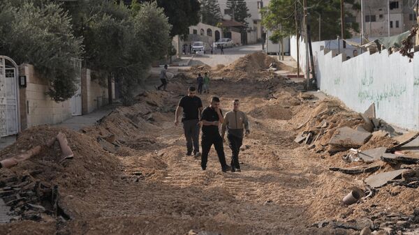 Unos palestinos caminan por una calle destruida después de una incursión del Ejército israelí en Yenín, Cisjordania - Sputnik Mundo