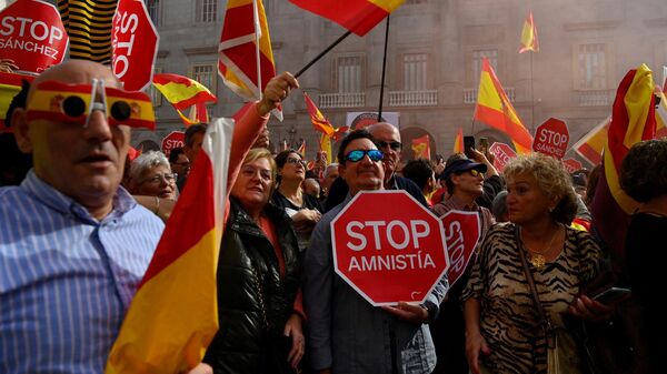 Manifestantes sostienen carteles de 'Stop Amnistía' y banderas españolas durante una protesta convocada por la oposición de derechas contra un proyecto de ley de amnistía, Barcelona, el 12 de noviembre de 2023 - Sputnik Mundo