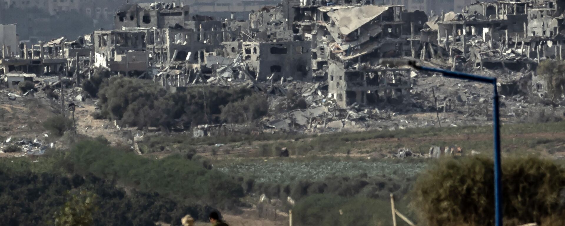Unos hombres caminan el 13 de noviembre de 2023 por la frontera con la Franja de Gaza, en el sur de Israel, en medio de los combates entre Israel y el grupo militante palestino Hamás - Sputnik Mundo, 1920, 01.12.2023