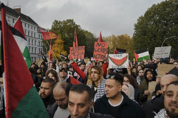 Manifestantes sostienen pancartas y banderas durante una concentración propalestina en Berlín, Alemania, el 28 de octubre de 2023. - Sputnik Mundo