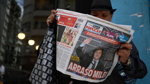 Un hombre lee un periódico argentino el 20 de noviembre de 2023, en Buenos Aires, cuya portada muestra la victoria del candidato de la alianza La Libertad Avanza, Javier Milei, en la segunda vuelta de las elecciones presidenciales.  - Sputnik Mundo