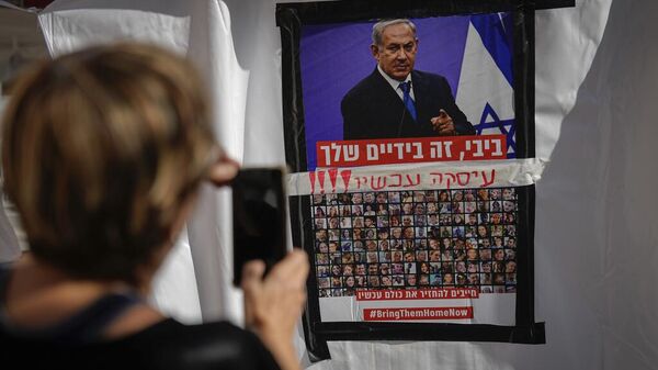 Un poster de Benjamin Netanyahu sobre los rostros de los rehenes tomados por Hamás el pasado 7 de octubre - Sputnik Mundo