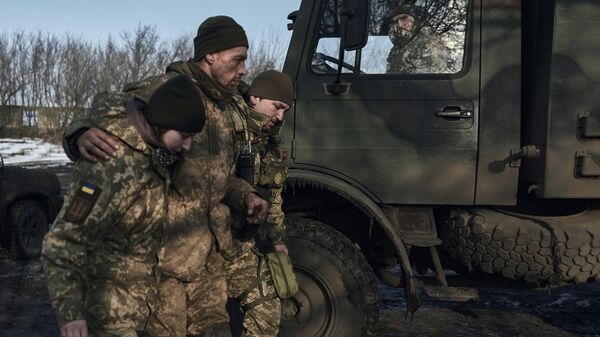 Médicos militares ayudan a un soldado herido en combate a subir a un vehículo de evacuación cerca de Bájmut, en la región ucraniana de Donetsk, el 22 de febrero de 2023 - Sputnik Mundo