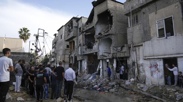 Palestinos inspeccionan un edificio dañado tras una incursión militar israelí en la ciudad de Tulkarem, Cisjordania. - Sputnik Mundo