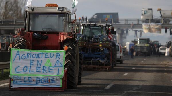 Un tractor con una pancarta en la que se lee agricultor enfadado en protesta por los impuestos y la disminución de ingresos, al sur de Toulouse, Francia - Sputnik Mundo