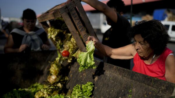 Una anciana recoge verduras en un mercado de Buenos Aires - Sputnik Mundo