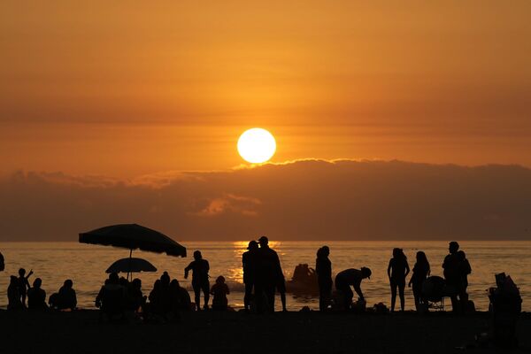 Lima, la capital de Perú, es muy popular entre los visitantes no sólo por sus casi 500 años de historia, sino también por las arenas blancas o doradas de sus playas, así como por el hermoso color verdoso de las aguas oceánicas debido a la acumulación de plancton.En la foto: turistas admiran la puesta de sol en la playa de Sombrilla, en Lima (Perú). - Sputnik Mundo