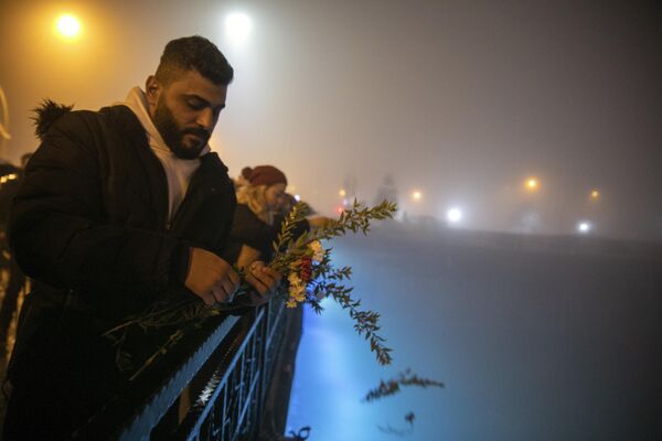 Varias personas arrojan claveles al río Orontes en memoria de las víctimas del terremoto en Antioquía. - Sputnik Mundo