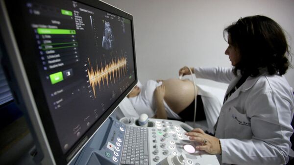 Un ginecólogo realiza una ecografía a una mujer embarazada - Sputnik Mundo