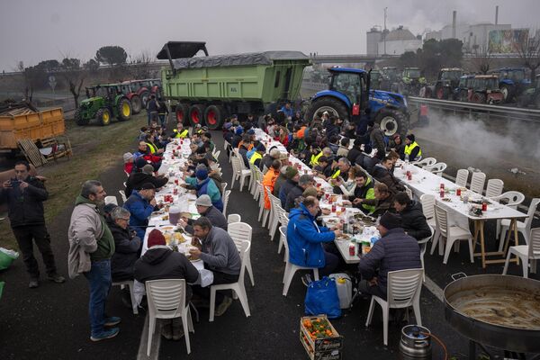 Agricultores españoles que participan en una protesta cerca de Mollerussa almuerzan en una autopista bloqueada. - Sputnik Mundo