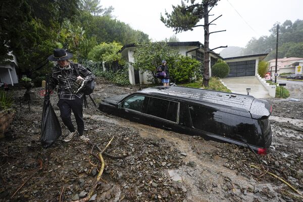 Personas abandonan sus casas en el vecindario de Beverly Crest, en Los Ángeles, California (EEUU), tras un deslave provocado por una fuerte tormenta. - Sputnik Mundo