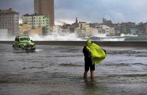 Un turista toma una foto del paseo inundado del Malecón en La Habana, Cuba, durante las inundaciones causadas por un frente frío. - Sputnik Mundo