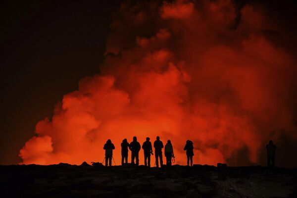 Personas observan una erupción volcánica cerca de Grindavík, Islandia. - Sputnik Mundo