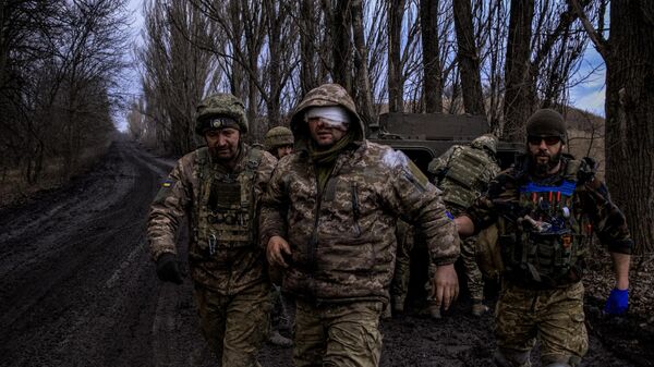 Médicos de combate ucranianos evacuan a un militar ucraniano herido de la línea del frente cerca de Artiómovsk (Bajmut) - Sputnik Mundo