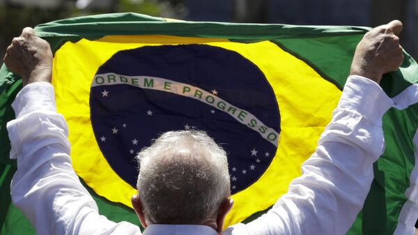 El presidente de Brasil, Lula da Silva, sosteniendo una bandera de Brasil durante la campaña electoral de 2022 - Sputnik Mundo