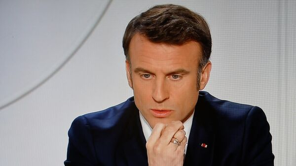 Una pantalla de televisión que emite al presidente de Francia, Emmanuel Macron, dirigiéndose a una entrevista en directo en los canales de televisión franceses TF1 y France 2 en el Palacio Presidencial del 
Elíseo en París  - Sputnik Mundo
