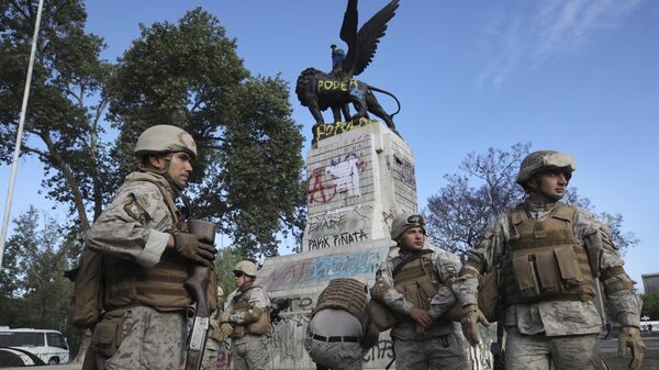 Soldados montan guardia cerca de grafitis realizados por un manifestante antigubernamental durante la histórica marcha del viernes en Santiago de Chile, el sábado 26 de octubre de 2019  - Sputnik Mundo