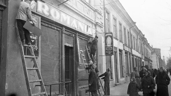 Los habitantes de la ciudad de Odesa liberada retiran las placas con los nombres de las tiendas rumanas que dejaron los ocupantes de Alemania y Rumania  - Sputnik Mundo