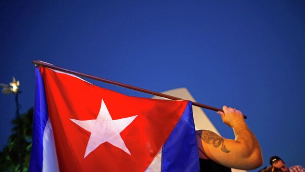 An anti-Castro Cuban exile holds a Cuban flag during a protest after the announcement of restoring diplomatic ties between Cuba and United States, at an area knows as 'Little Havana' in downtown Miami, Florida December 17, 2014. - Sputnik Mundo