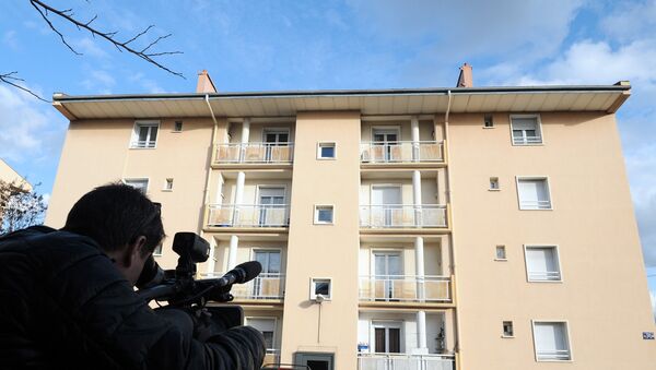 A man films on January 20, 2015 a building in Beziers, where a Russian Chechen suspected of preparing a terrorist attack was living before his January 19 arrest. - Sputnik Mundo