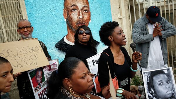 Demonstrators rally against the Missouri grand jury's decision to not indict Darren Wilson for his fatal shooting of Michael Brown, in front of a mural of Ezell Ford - Sputnik Mundo
